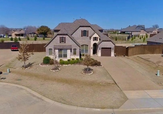 french provincial home featuring concrete driveway, a garage, fence, and stone siding