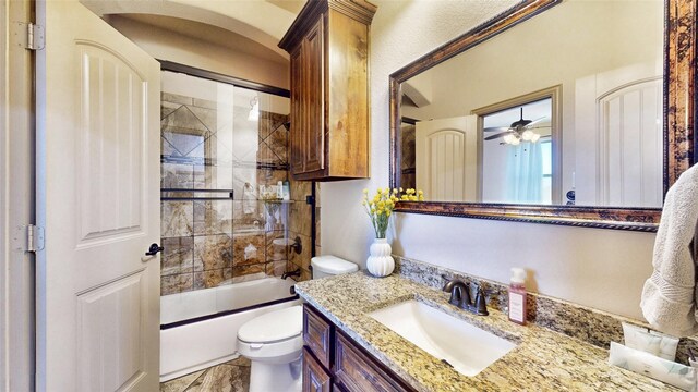 full bathroom with vanity, toilet, bath / shower combo with glass door, and ceiling fan