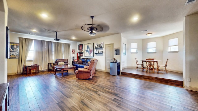 living area featuring wood finished floors, visible vents, and baseboards