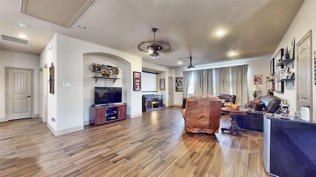 living room with attic access, wood finished floors, visible vents, and baseboards