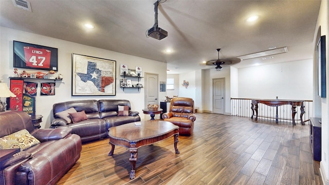 living room with recessed lighting, wood finished floors, and visible vents