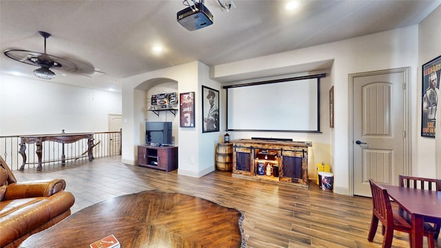 cinema room with ceiling fan, baseboards, wood finished floors, and recessed lighting