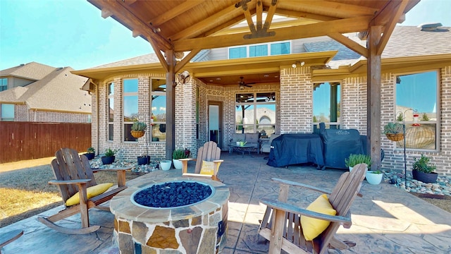 view of patio with ceiling fan, fence, and an outdoor fire pit