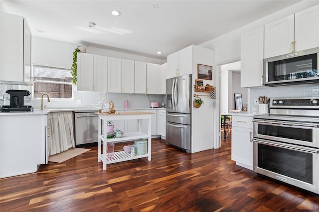 kitchen with dark wood-style floors, backsplash, appliances with stainless steel finishes, and light countertops