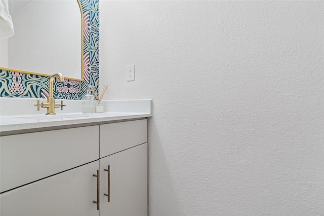 bathroom featuring vanity and a textured wall