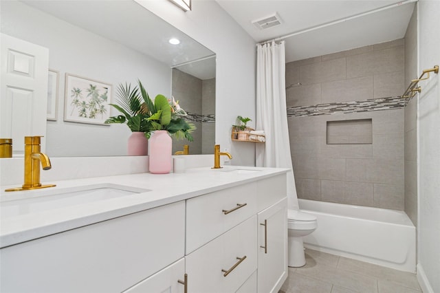 bathroom with double vanity, toilet, visible vents, and a sink