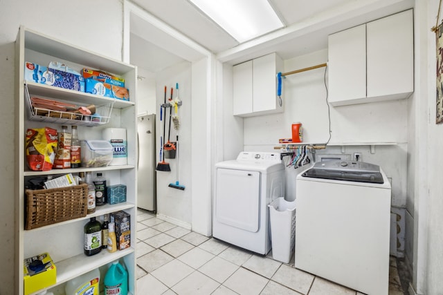 laundry room with cabinet space, light tile patterned floors, and independent washer and dryer