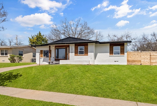 view of front of property featuring a front lawn, fence, and brick siding