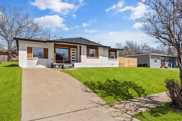 view of front of home with brick siding, concrete driveway, and a front yard