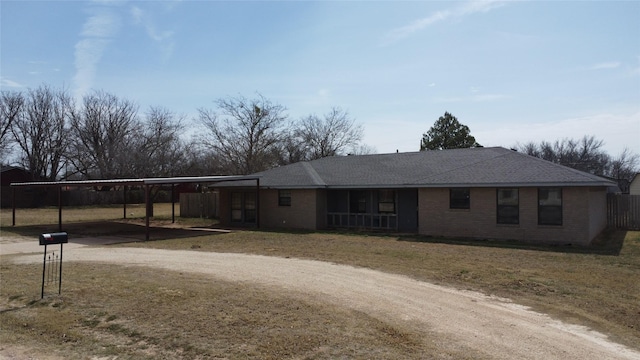 ranch-style house featuring fence, brick siding, driveway, and a shingled roof