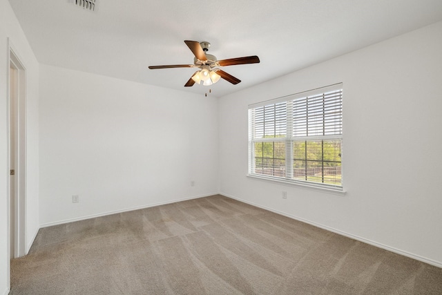 empty room with visible vents, ceiling fan, baseboards, and carpet