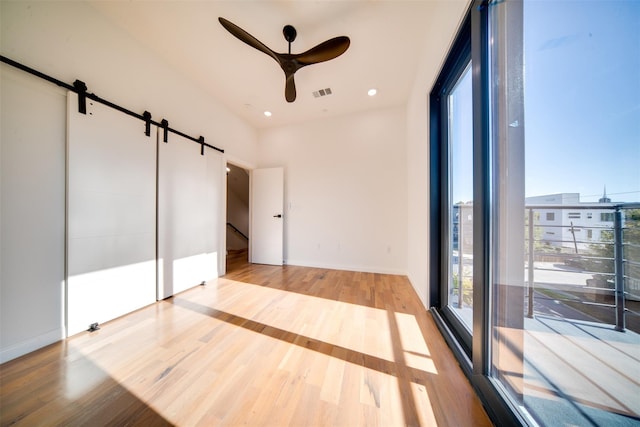 interior space featuring visible vents, wood finished floors, recessed lighting, a barn door, and ceiling fan