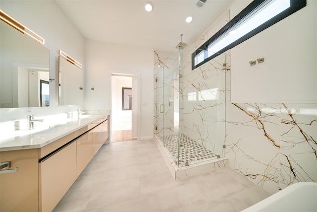 bathroom featuring double vanity, a freestanding tub, a marble finish shower, and a sink