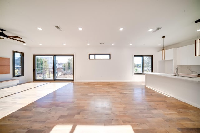 unfurnished living room with visible vents, recessed lighting, baseboards, and light wood-style floors