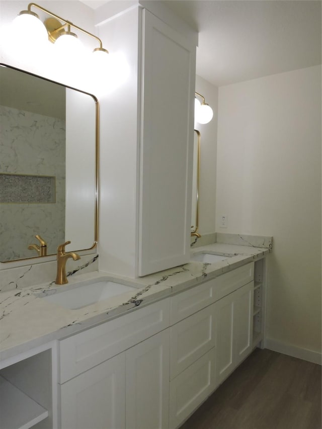 full bath featuring double vanity, wood finished floors, and a sink