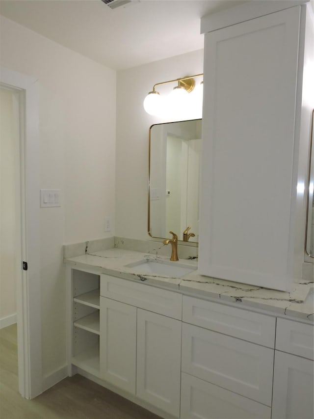 bathroom with visible vents, baseboards, wood finished floors, and vanity