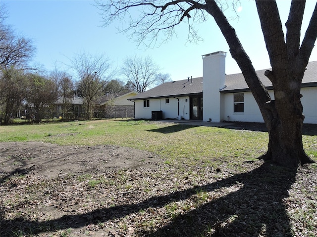 back of house with fence, a yard, central AC, a chimney, and a patio area