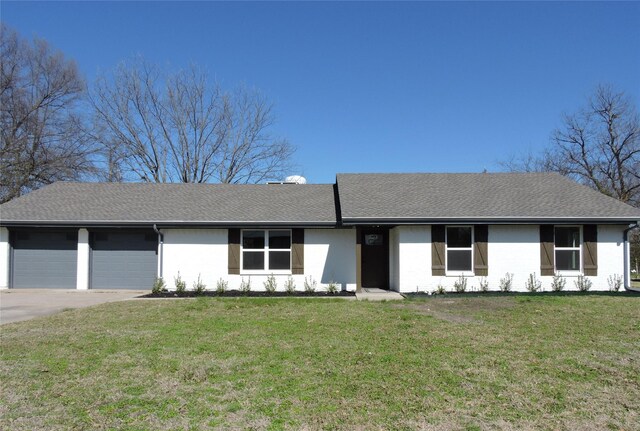 ranch-style house featuring a front lawn, a garage, driveway, and a shingled roof