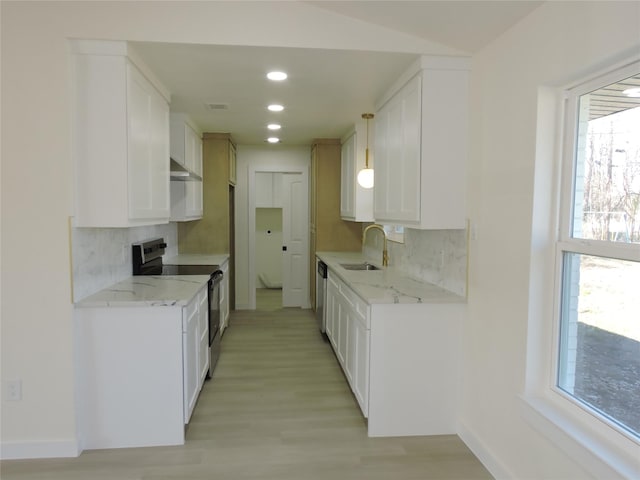 kitchen featuring a sink, under cabinet range hood, backsplash, white cabinetry, and appliances with stainless steel finishes