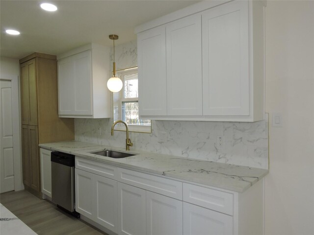 kitchen with a sink, stainless steel dishwasher, and white cabinetry