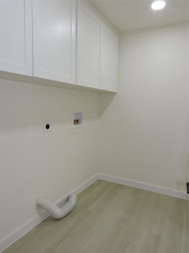 laundry area with hookup for a washing machine, baseboards, light wood finished floors, cabinet space, and electric dryer hookup