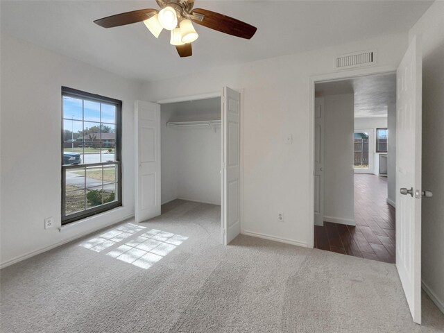 carpeted spare room featuring ceiling fan and baseboards