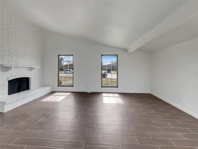 unfurnished living room featuring a brick fireplace, vaulted ceiling with beams, and wood finish floors