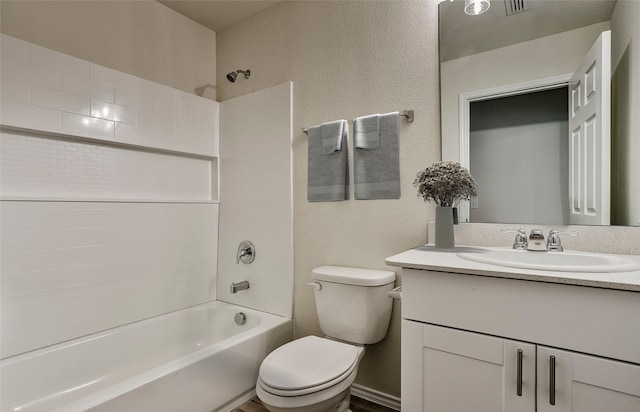 bathroom with shower / tub combination, toilet, vanity, and a textured wall