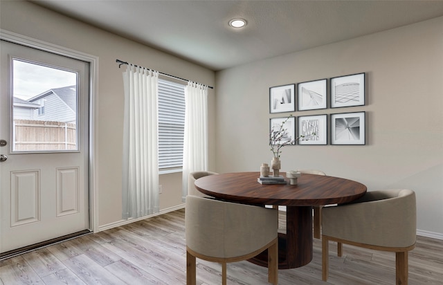 dining room with baseboards and light wood finished floors