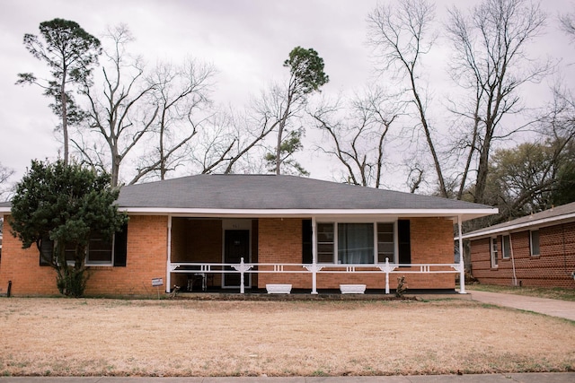 ranch-style home with a porch and brick siding