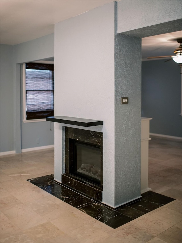 room details featuring a fireplace, baseboards, and ceiling fan