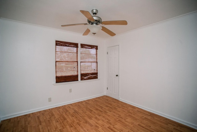 spare room featuring baseboards, light wood-style flooring, a ceiling fan, and ornamental molding