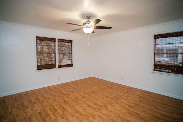 spare room featuring ceiling fan, baseboards, light wood-style floors, and ornamental molding