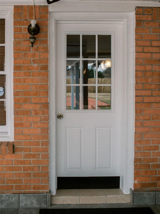 property entrance featuring brick siding