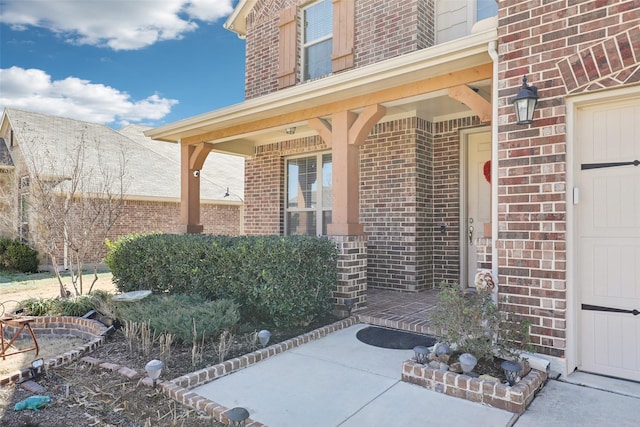 property entrance with brick siding and covered porch