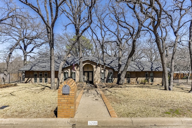 view of front of house with fence and brick siding