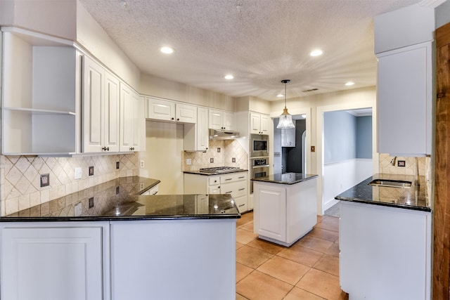 kitchen featuring open shelves, appliances with stainless steel finishes, a peninsula, light tile patterned flooring, and a sink