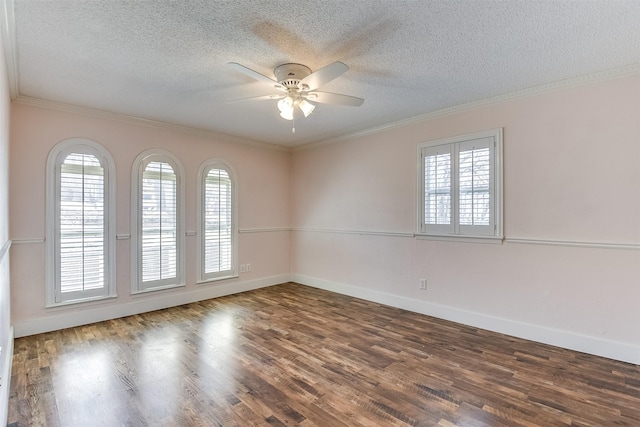 spare room with ornamental molding, a textured ceiling, baseboards, and wood finished floors