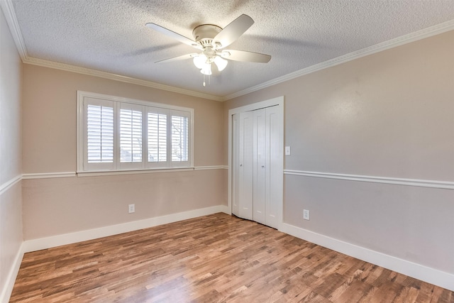 unfurnished bedroom with crown molding, baseboards, and wood finished floors