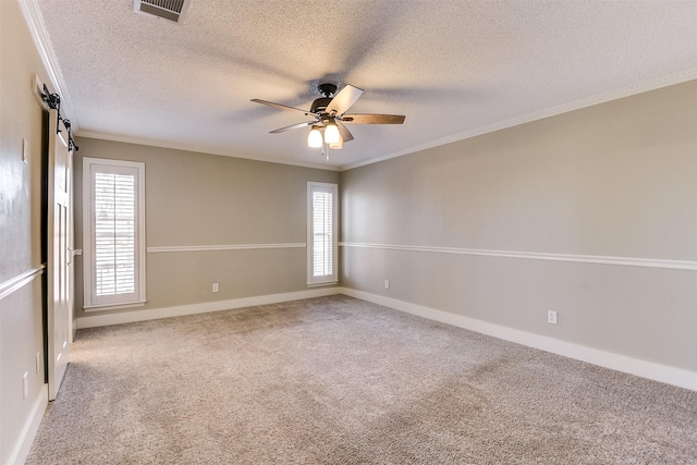 carpeted empty room featuring baseboards, a ceiling fan, visible vents, and ornamental molding