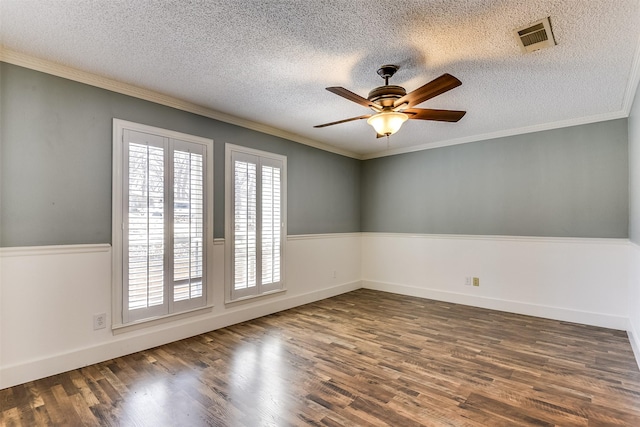 spare room featuring visible vents, ceiling fan, ornamental molding, wood finished floors, and a textured ceiling