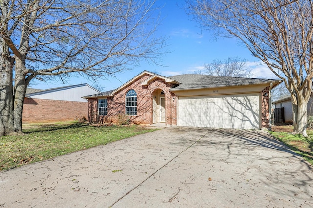 view of front facade featuring a front yard, an attached garage, a shingled roof, concrete driveway, and brick siding