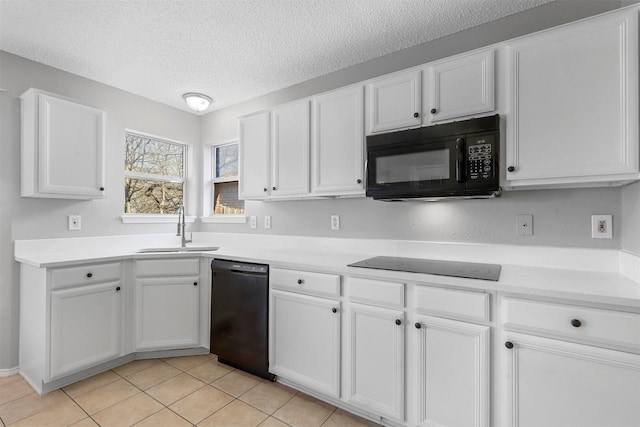 kitchen with black appliances, light countertops, a textured ceiling, white cabinetry, and a sink