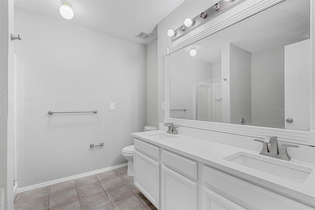 bathroom with a textured ceiling, toilet, visible vents, and a sink