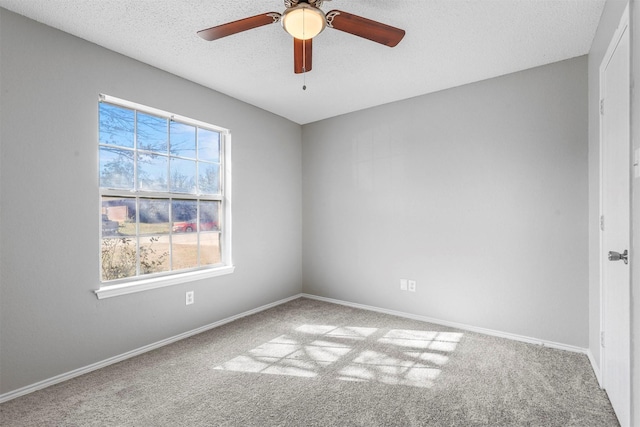 carpeted empty room featuring a ceiling fan, baseboards, and a textured ceiling