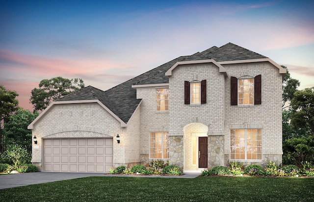 french country style house featuring a garage, driveway, brick siding, and a front lawn