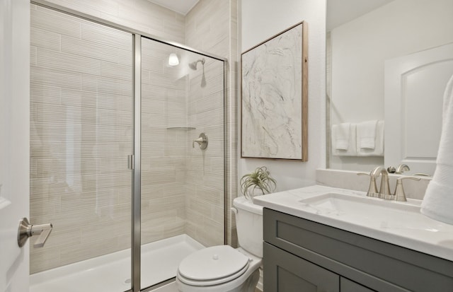 bathroom with vanity, toilet, and a shower stall