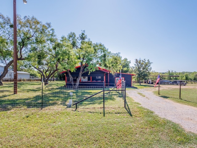 view of front of property featuring driveway, a front yard, and fence