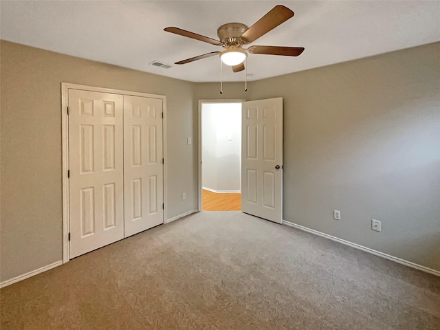 unfurnished bedroom with visible vents, baseboards, carpet floors, a closet, and a ceiling fan