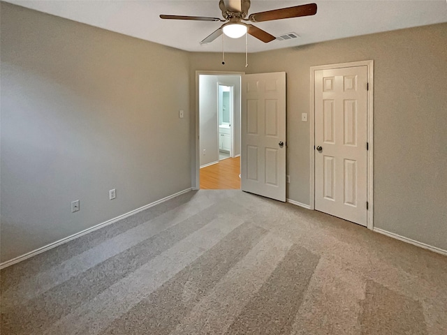 unfurnished bedroom featuring visible vents, carpet floors, baseboards, and a ceiling fan